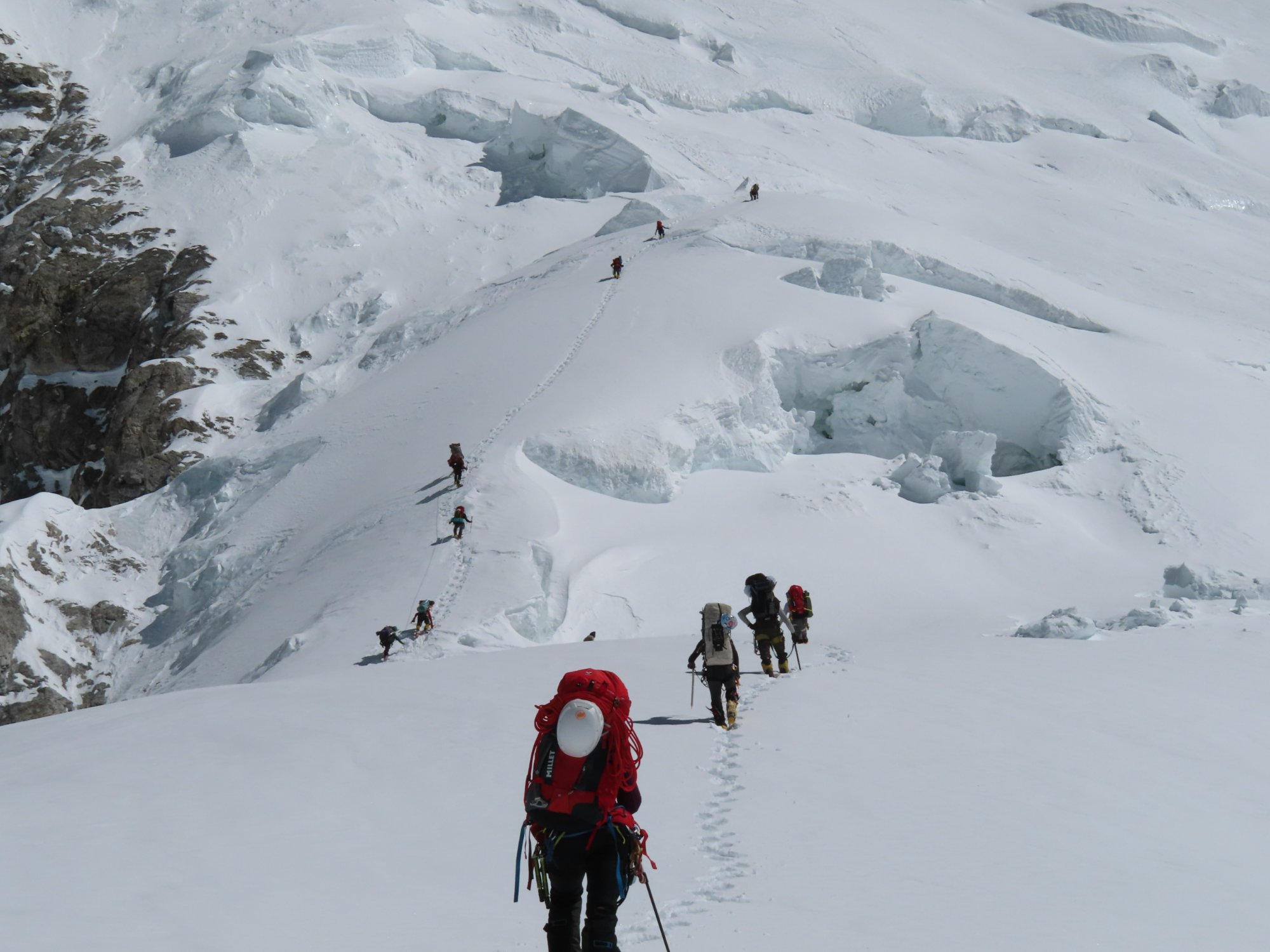 Mountain guides ascending a snowfield in the Karakoram
